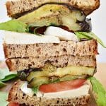 grilled eggplant caprese with arugula on wood cutting board