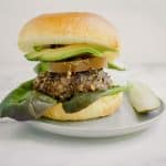 quinoa and mushroom blended burger on plate with pickle