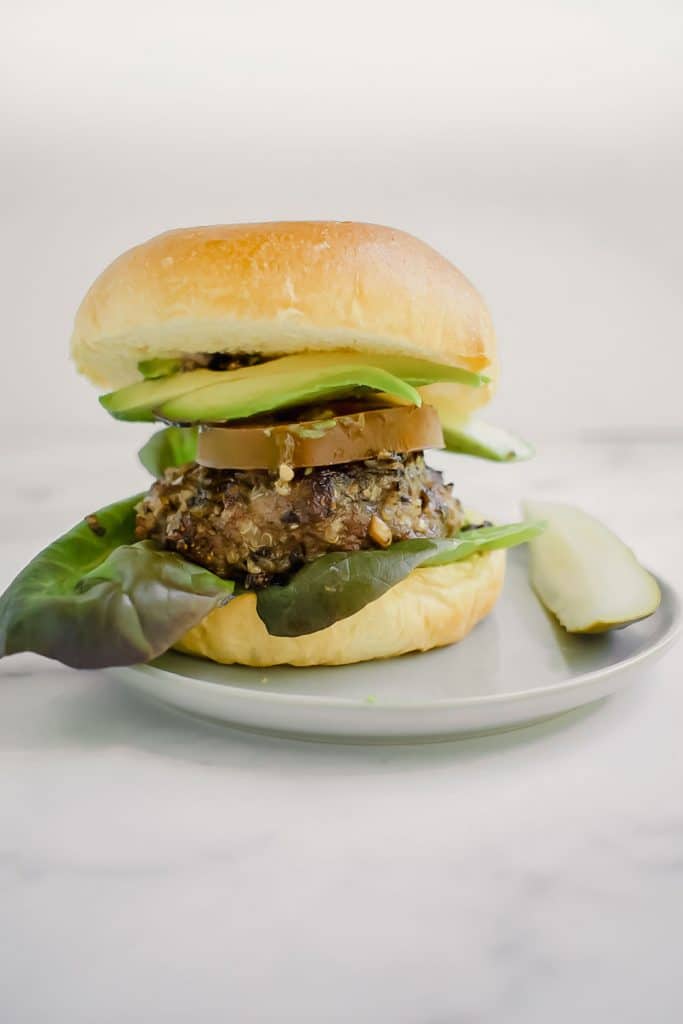 quinoa and mushroom blended burger on plate with pickle