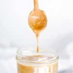spoon over jar of sauce dropping with penaut butter