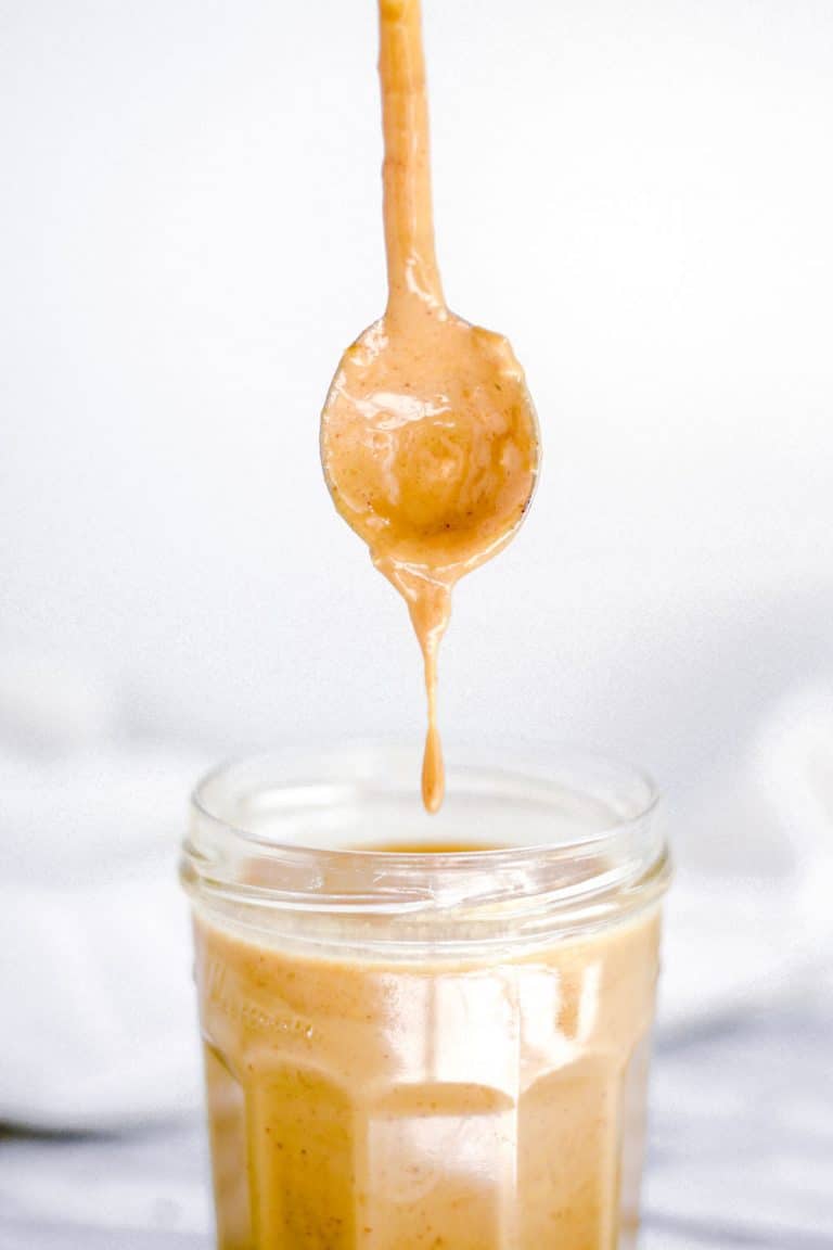 spoon over jar of sauce dropping with penaut butter