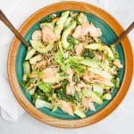soba noodle salad in a bowl on gray background with serving spoons in bowl