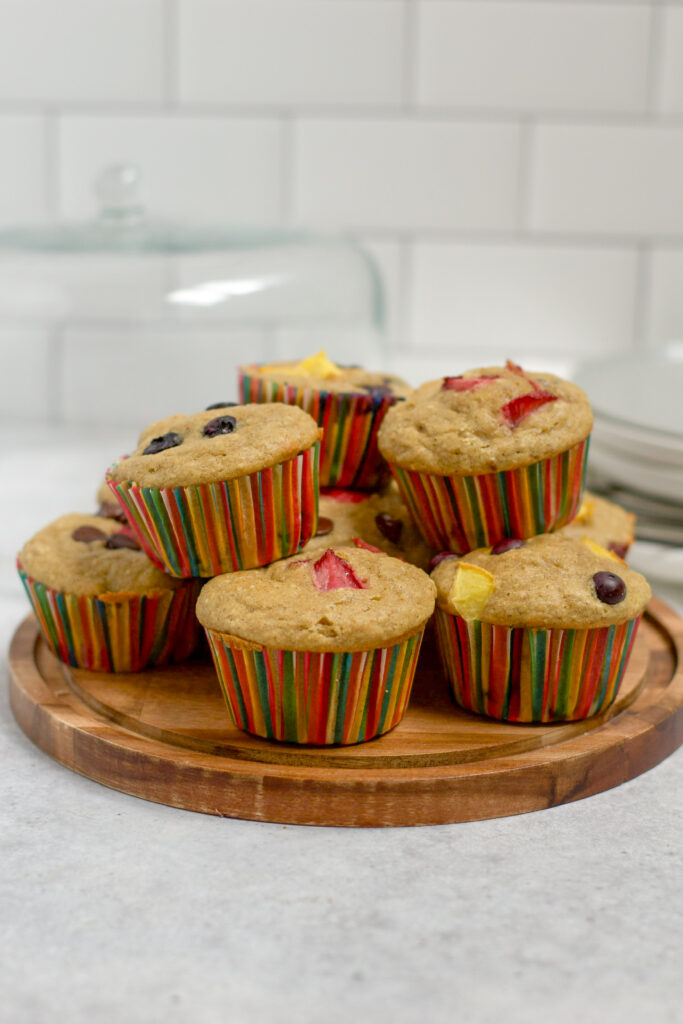 oat flour muffins mixed flavors on a cake holder with cover in the background